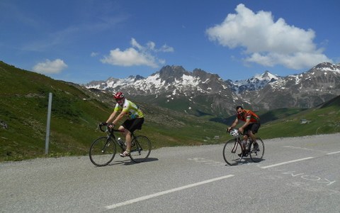Two cyclists climbing a high alpine pass